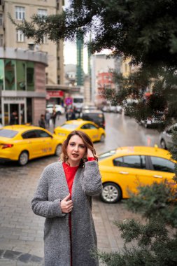 girl stands near road against the background taxi