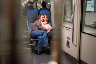 İki kız arkadaş metroya ya da füniküse biniyor.