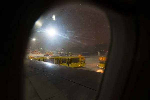 Autobus czekać na pasażerów samolot noc zima, okno — Zdjęcie stockowe