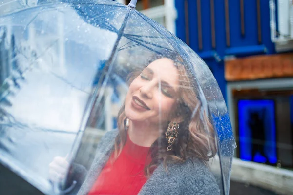 Açık kahverengi saçlı kız şemsiyenin altında mavi duvar — Stok fotoğraf