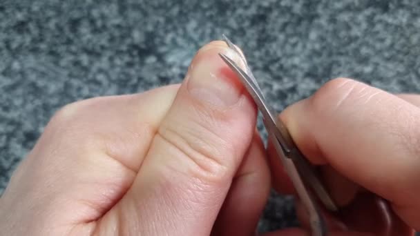 Cutting nails on a man's hand with scissors — ストック動画