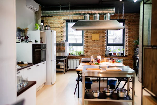 Cozinha com uma ilha de trabalho no meio e um capuz — Fotografia de Stock