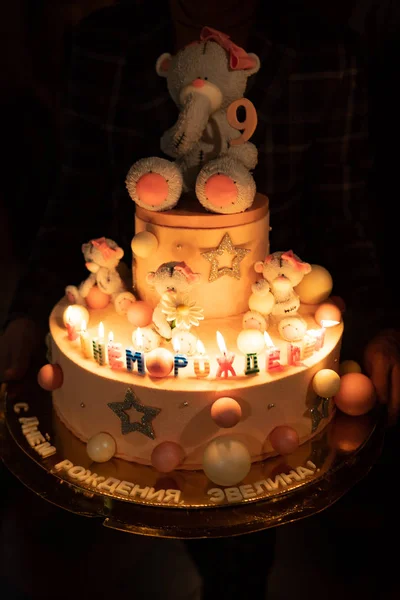 Birthday cake with bear and candles in the dark — Stockfoto