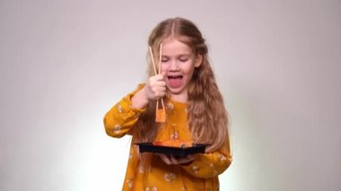 Little girl drops the roll, can't keep sticks.