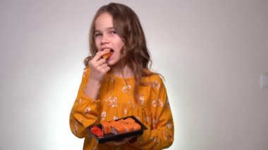Teenager girl eating roll from the black box.