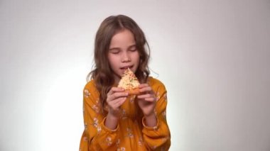 Pizzayı ısıran ve yiyen genç kız.