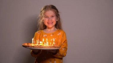 Little girl blows out candles on pizza birthday