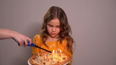 birthday of a little girl. Light candles on pizza. 