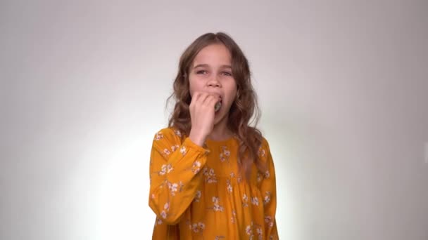 Girl puts roll in his mouth and looking at camera. — Stock video