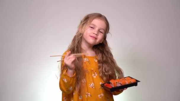 Girl posing with rolls and chopsticks in hand — Stockvideo