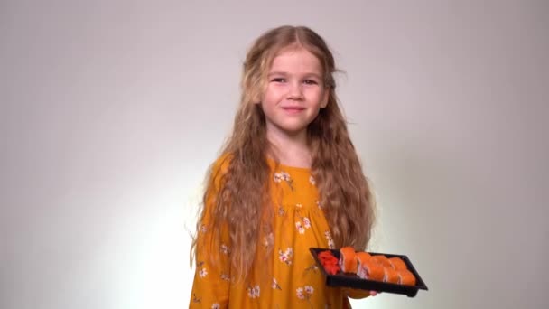 Little girl smiling with rolls and chopsticks — Stockvideo