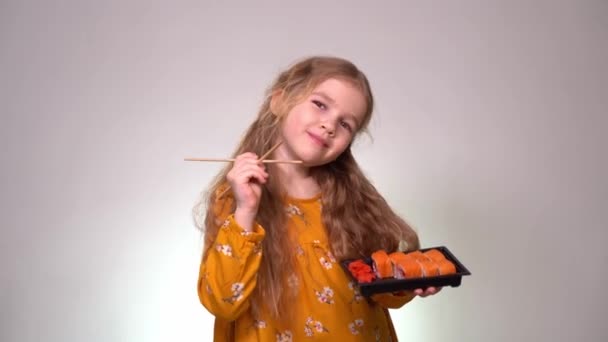 Niña sosteniendo una caja de rollos y palos — Vídeos de Stock