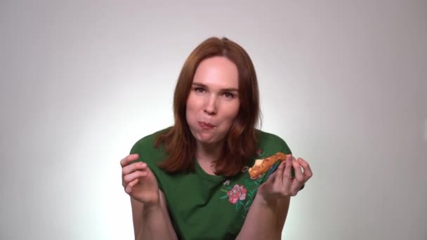 Kvinna med mat i munnen äter pizza, skrattar — Stockvideo