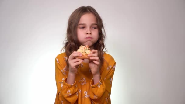 Teen girl biting and eating pizza, mouth full. — Wideo stockowe