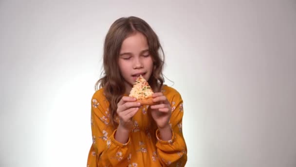 Adolescente chica mordiendo y comer pizza blanco fondo — Vídeos de Stock