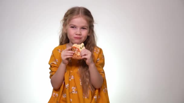 Little girl eating big piece pizza and laughing. — Stok video