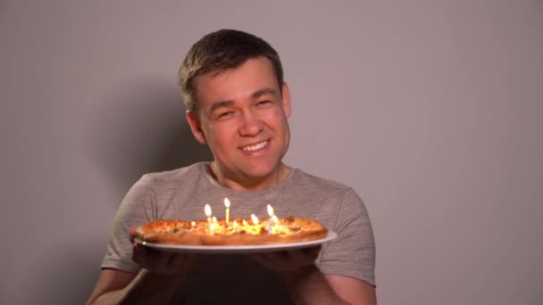 The man blows out candles on the pizza. Holiday — Stockvideo