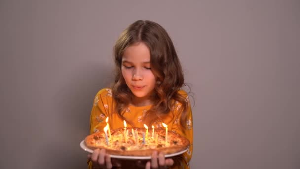 Genç kız pizzanın doğum gününde mumları üflüyor. — Stok video