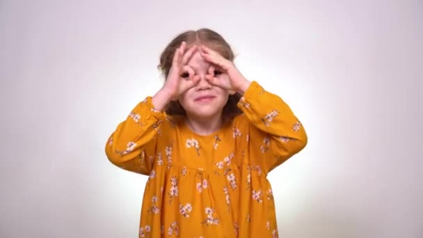 Finger glasses make a little girl blonde funny — Stock videók