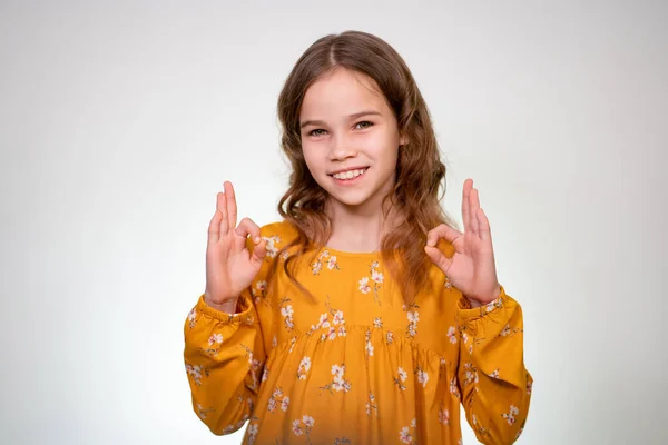 Adolescente menina mostrando OK sinal com o dedo, sorrindo — Fotografia de Stock