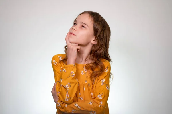 Sonhos. menina com cabelo leve segura dedo a cara — Fotografia de Stock