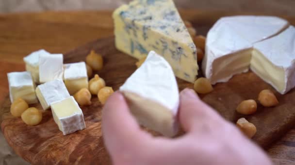 Cortar el queso Camembert sobre tabla de madera — Vídeo de stock