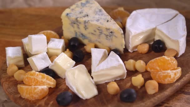 Ponha verdes em uma tábua de serviço com queijo . — Vídeo de Stock