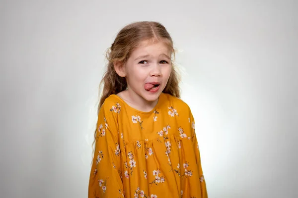 A little girl shows her tongue. — Stockfoto