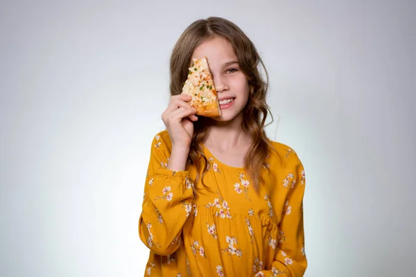 Adolescente chica sosteniendo un pedazo de pizza de una cara —  Fotos de Stock