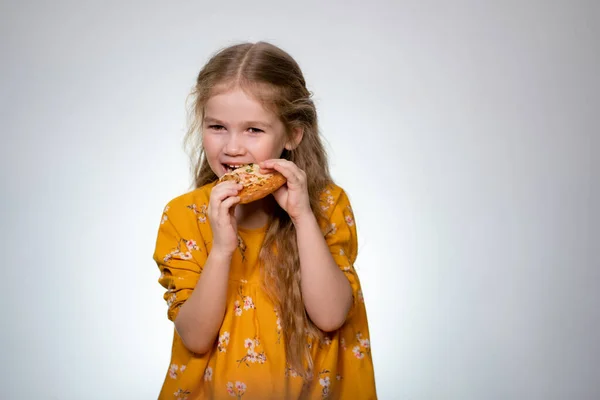 Маленькая девочка ест пиццу и смеется . — стоковое фото