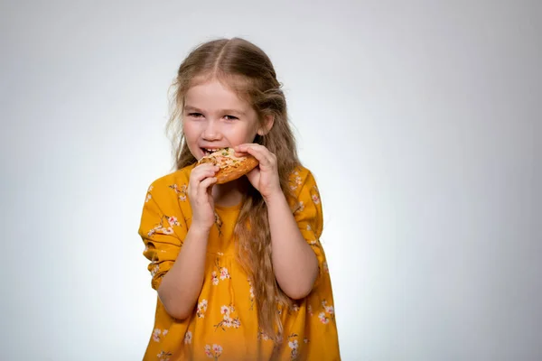 The little girl eating the pizza and laughing. — Stockfoto