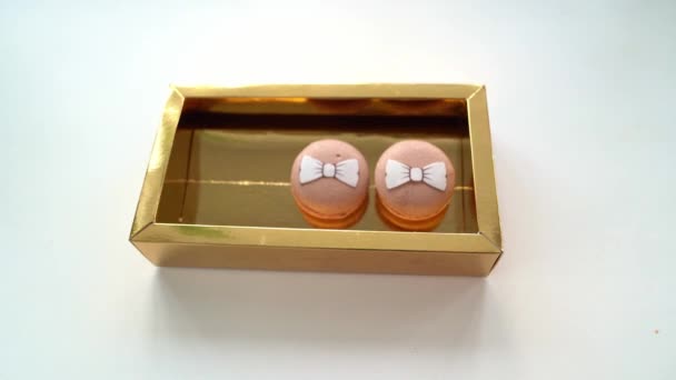 Kuchen Makronen mit Schleifen in einer goldenen Schachtel — Stockvideo