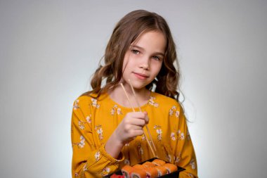 Genç bir kız rulo tutuyor, suşi tutuyor ve hapşırıyor..