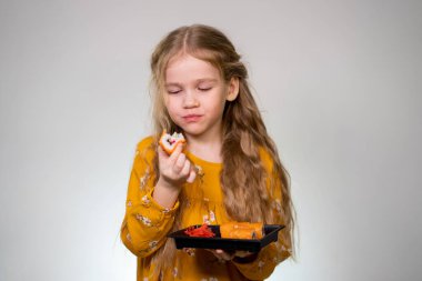 The girl bites tasty rolls and holds in hands.