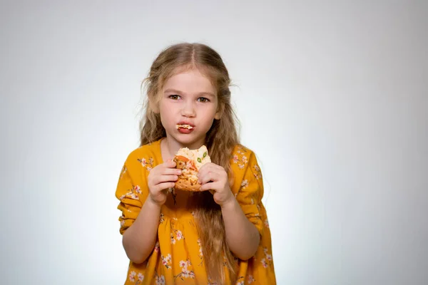 The little girl eating the pizza and laughing. — Stockfoto