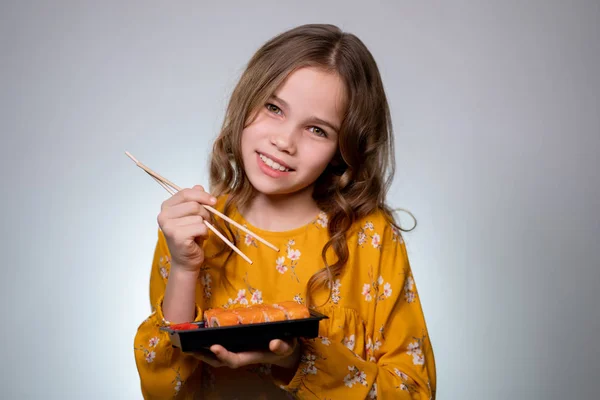 Teenager girl holding roll, sushi and sneezes. — Stockfoto