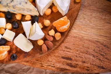 pieces of cheese on a wooden Board. empty space.