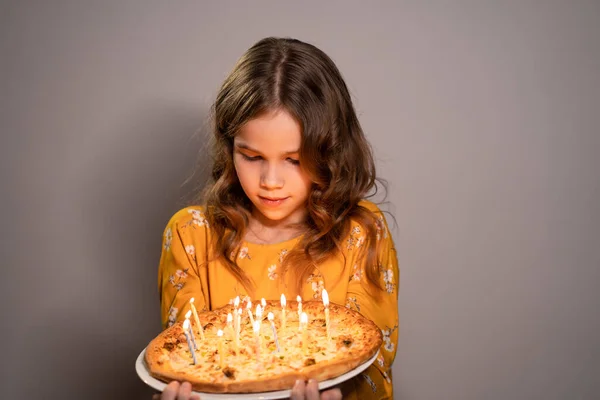 Girl teen holding pizza with candles looks fire — Stockfoto