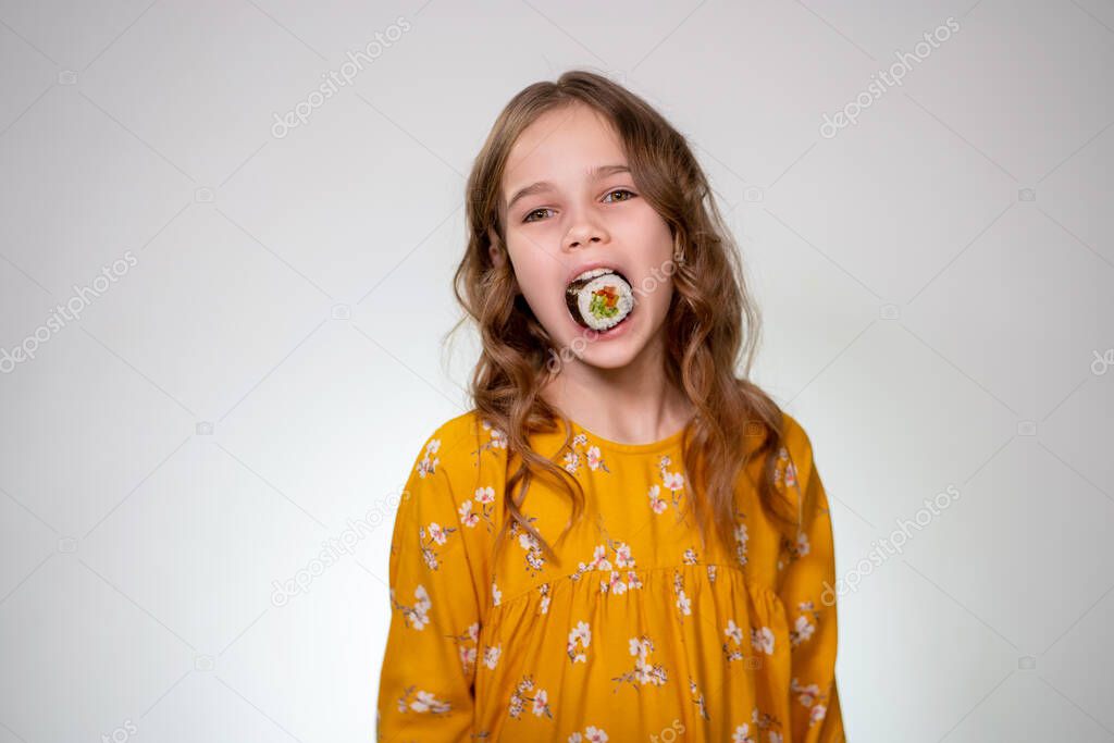 Girl puts roll in his mouth and looking at camera.