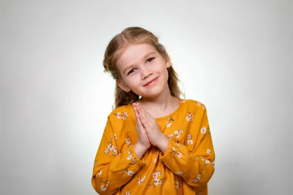 Little blonde girl fold her hands like an angel — Stockfoto