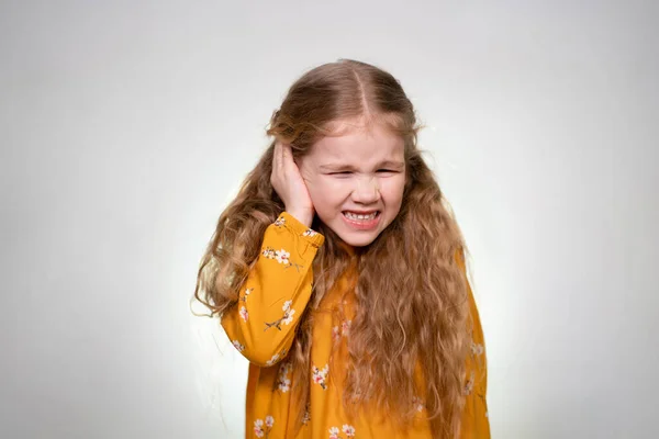 Kızın kulağı ağrıyor, kulağını elle tut.