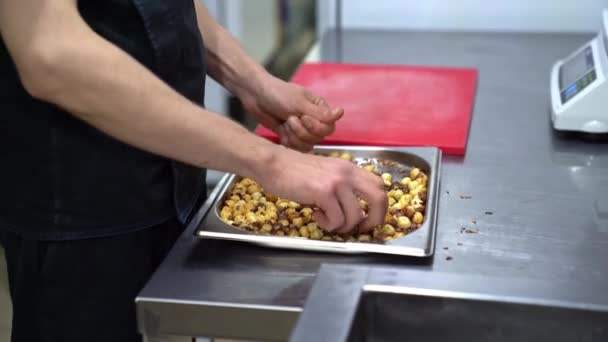 Nuts clean hands from husk in a restaurant kitchen — Stock Video
