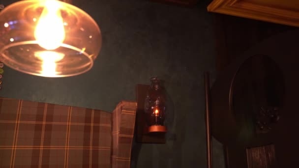 Olielamp op de muur in het donkere hok van de pub — Stockvideo