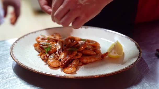 Mains cuisiniers mettre des verts sur les crevettes frites au citron . — Video