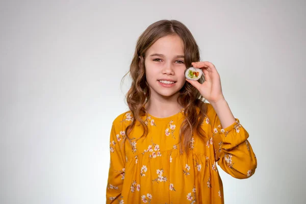 Teen girl puts one roll to the eye and smiles. — Stockfoto