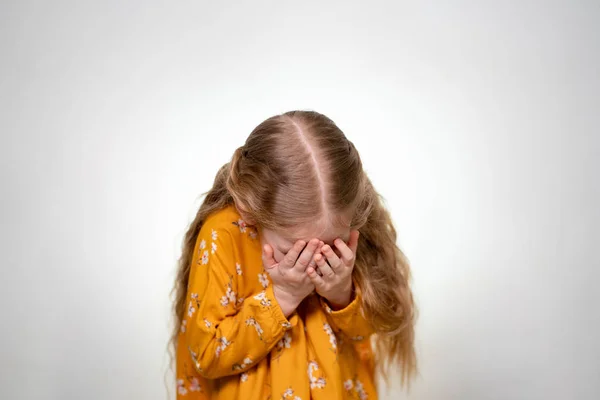 Niña asustada y cubre su cara con sus manos — Foto de Stock