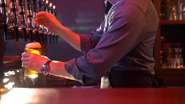 Barmen fıçıdan bira doldurur ve masaya koyar. — Stok video