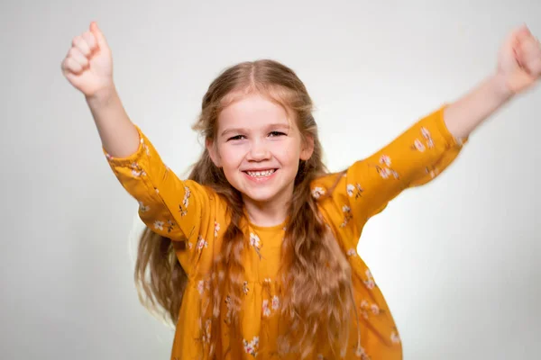 The little girl is happy and waving his arms top — Stockfoto