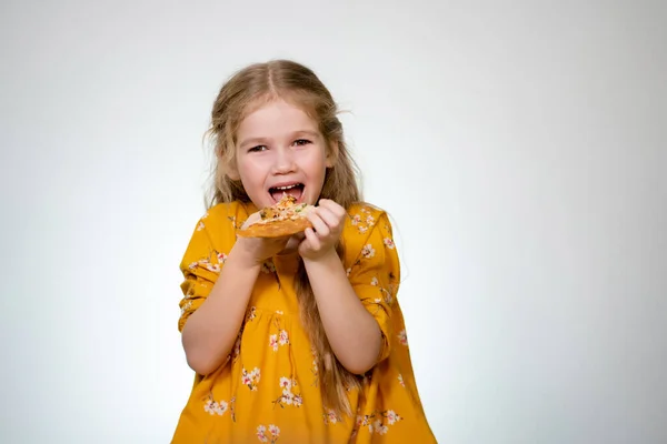 Geburtstagspizza. Das kleine Mädchen isst und lacht. — Stockfoto
