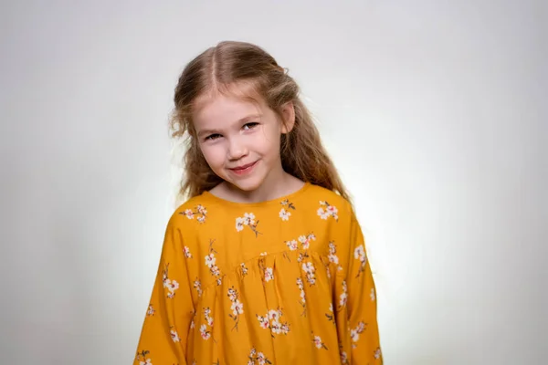 La bambina sorride e guarda la macchina fotografica . — Foto Stock